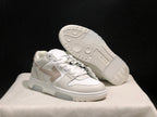 Angled view showing one sneaker outsole with circular tread details and the layered upper design of the other shoe.