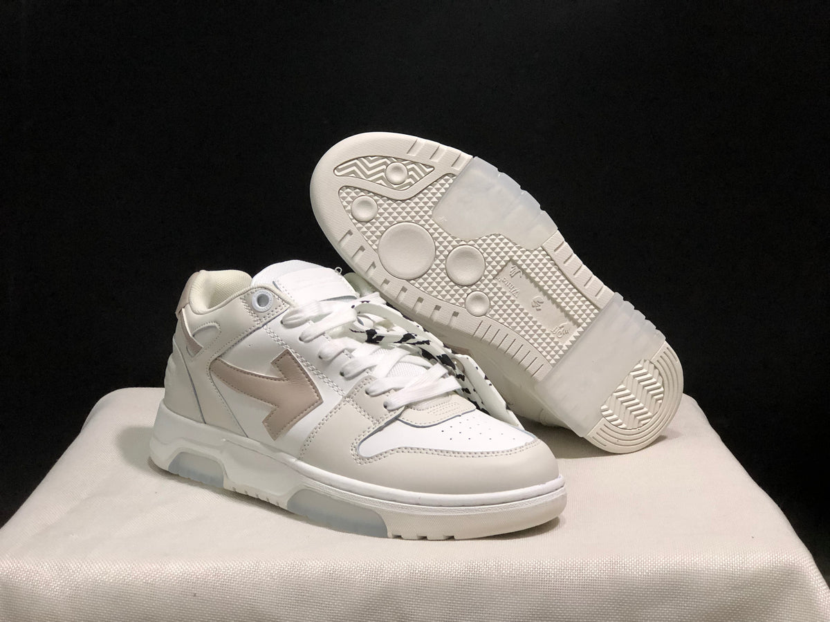 Angled view showing one sneaker outsole with circular tread details and the layered upper design of the other shoe.