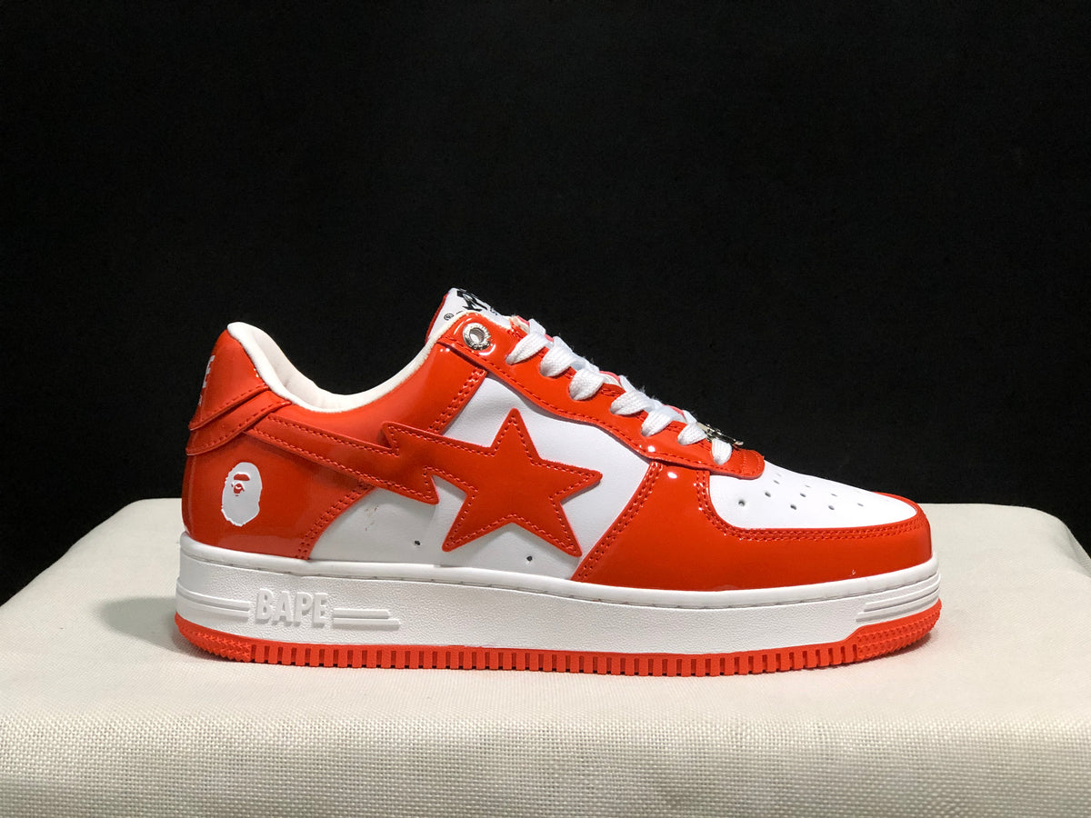 Close side view showing the orange star-shaped side detail, BAPE heel graphic, white midsole, and orange outsole.