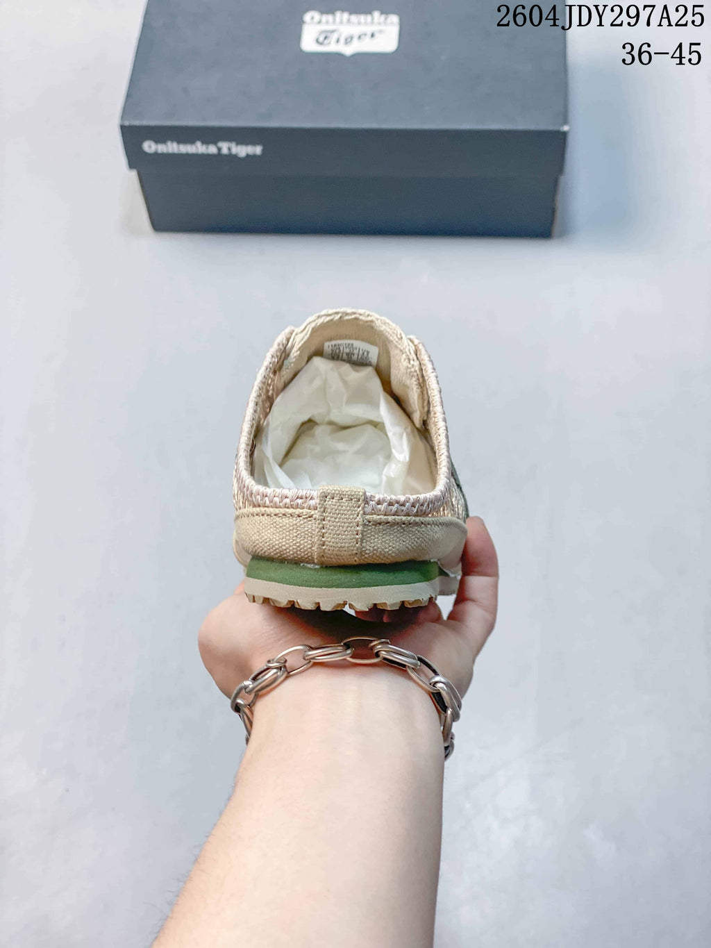 Rear view of the beige slip-on sneaker showing the heel construction and outsole edge.