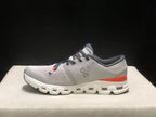 Side profile of one silver and flame shoe showing the On logo, lace-up construction, and segmented sole.