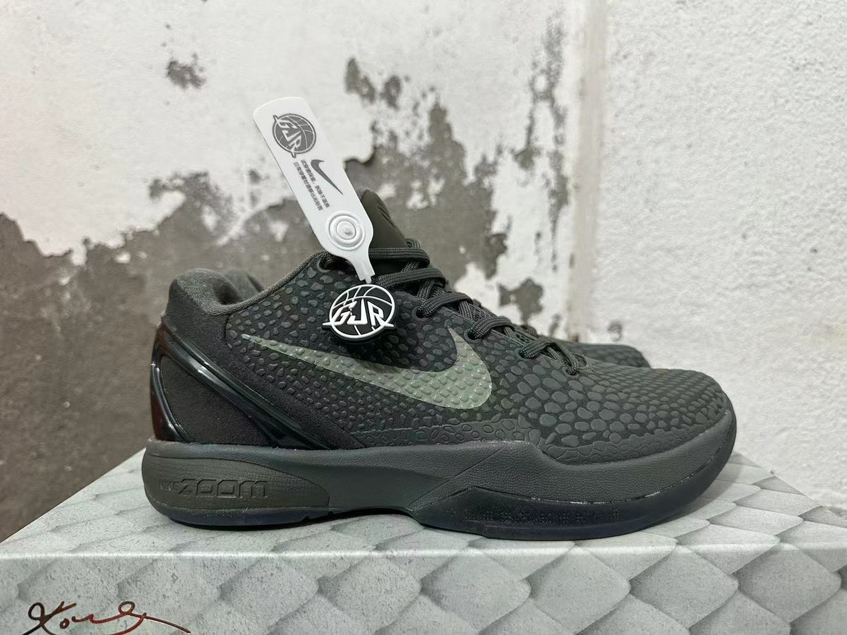 Side profile of a dark Nike Kobe 6 shoe with contrasting Swoosh and textured upper