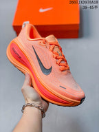 Orange Nike Vomero Plus running shoe with a darker swoosh and contrasting red-orange midsole details.