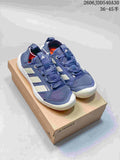 Pair of blue Adidas Terrex Daroga 25 sneakers on a shoebox, showing the lace-up fronts and light-colored side stripes.