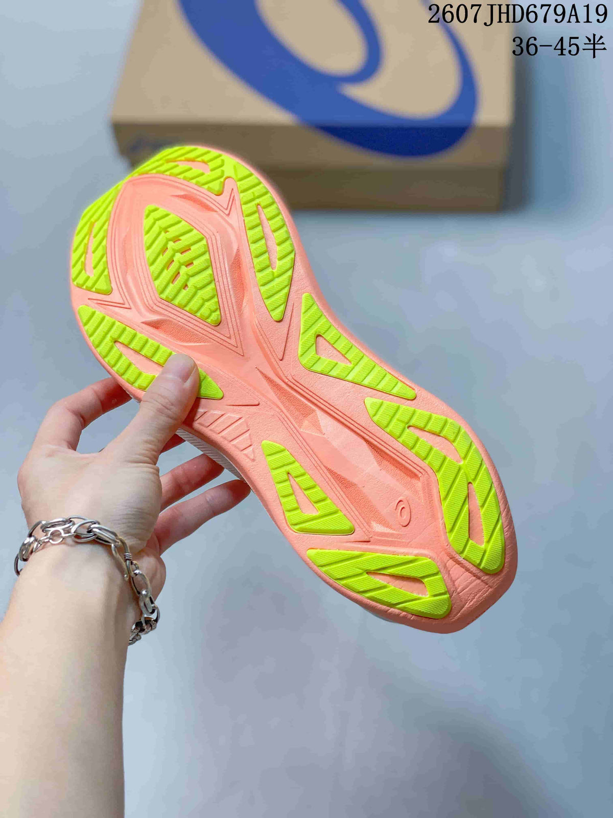 Close view of the coral and lime patterned outsole on an ASICS Superblast 2 Paris running shoe.