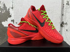 Pair of red Nike basketball sneakers with black Swooshes and neon green laces