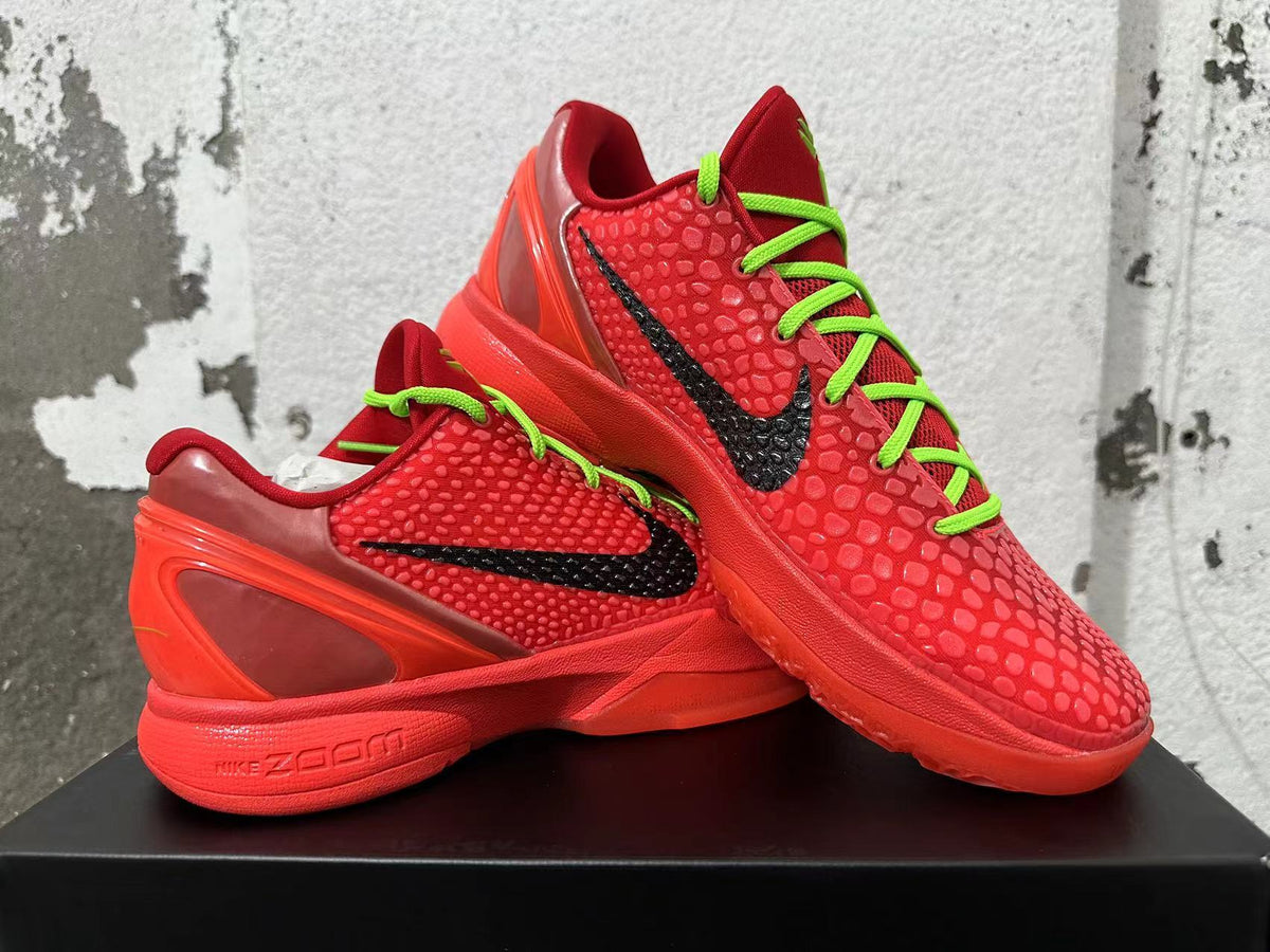Pair of red Nike basketball sneakers with black Swooshes and neon green laces