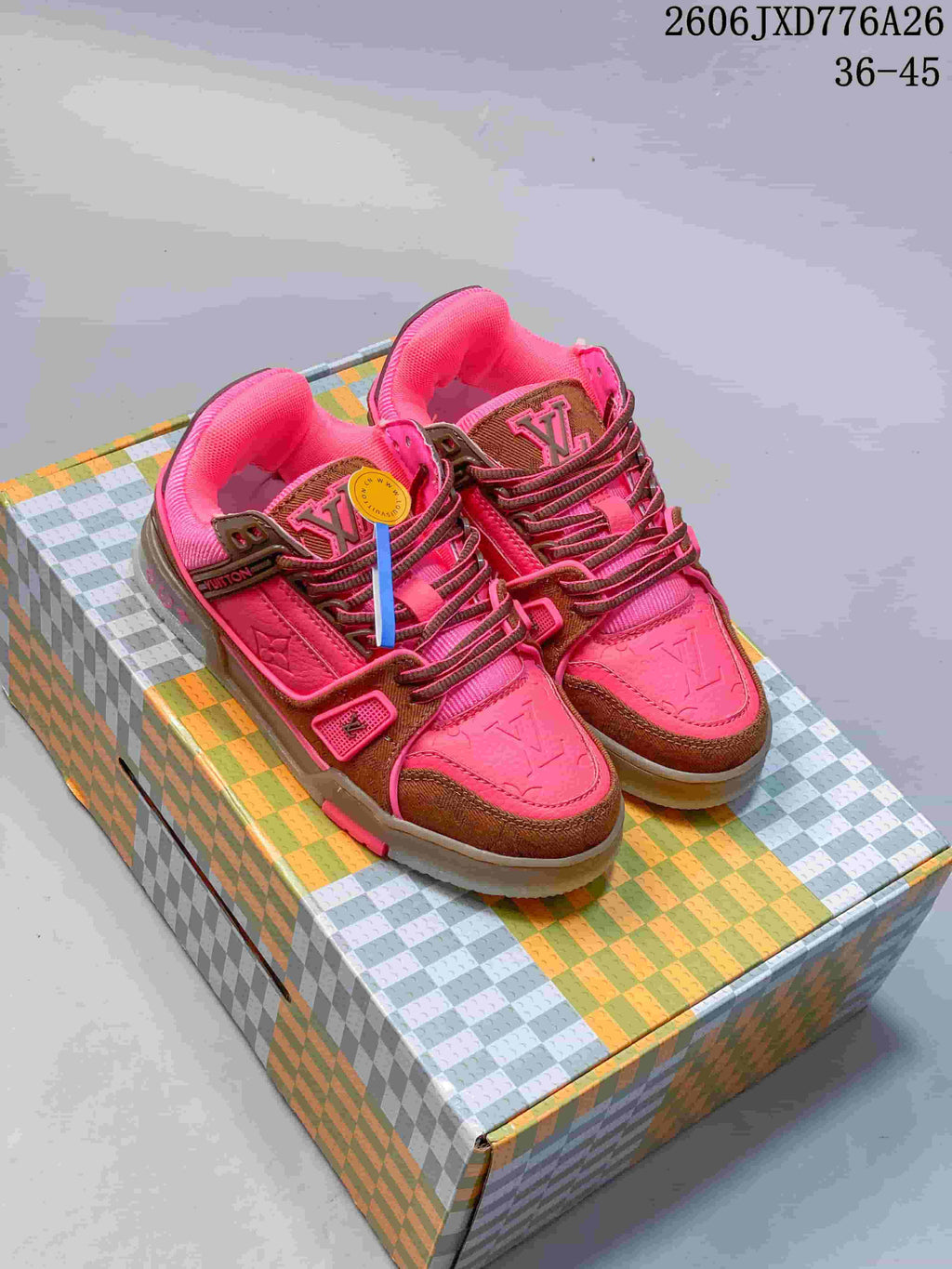 Pair of pink and brown Louis Vuitton Trainer low-top sneakers on a patterned box
