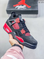 Close-up of a black high-top sneaker with red eyelets, red side mesh, and red midsole accents.