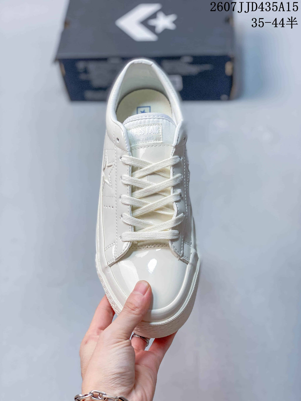 Top view of the white lace-up sneaker showing the tongue, laces and glossy toe area.