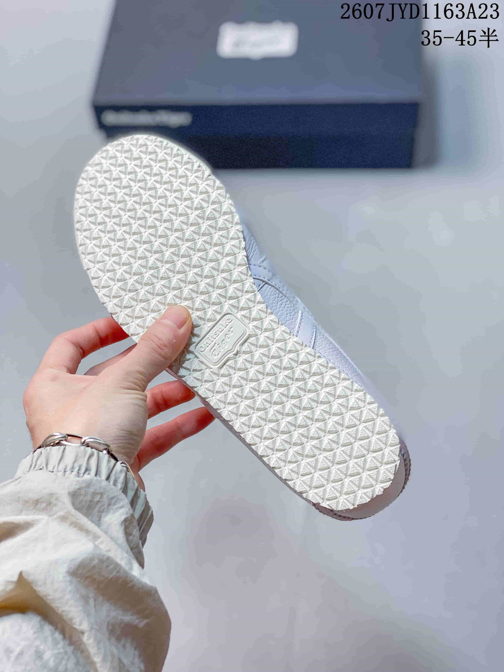 Outsole view showing the sneakers' repeating textured tread pattern.