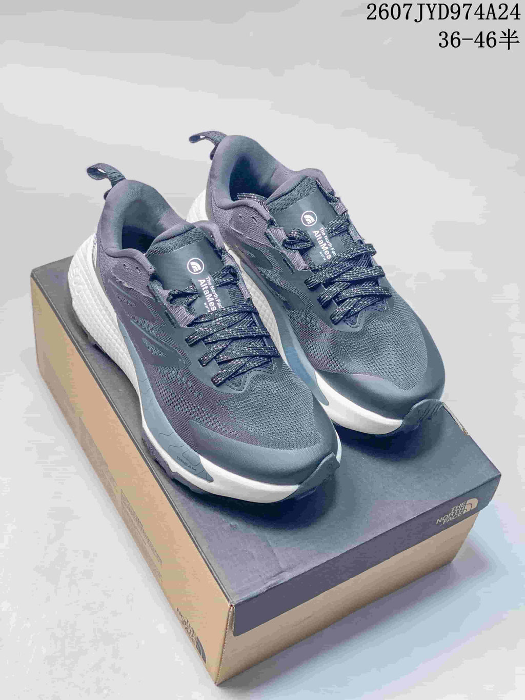 Pair of dark gray The North Face Altamesa 500 sneakers displayed on a shoebox, with white midsoles and black outsoles.
