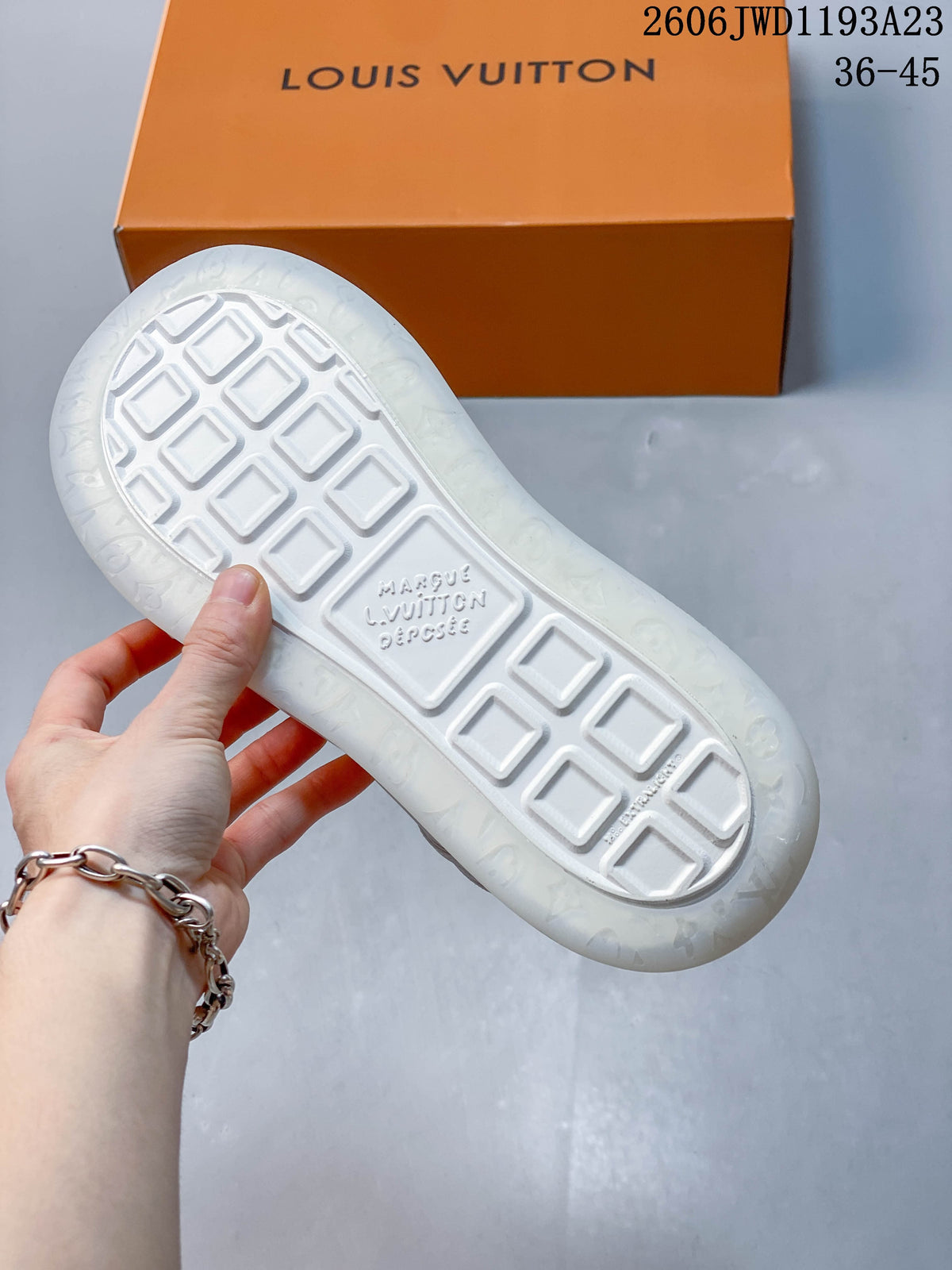 Underside of a white sneaker showing a geometric tread pattern