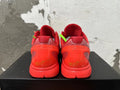 Rear view of red Nike Kobe basketball shoes with bright green lace accents