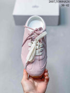 Top view of the pink sneaker showing the lace arrangement, tongue, and rounded toe.