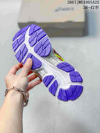 Close view of the shoe outsole showing a white base with purple segmented tread.