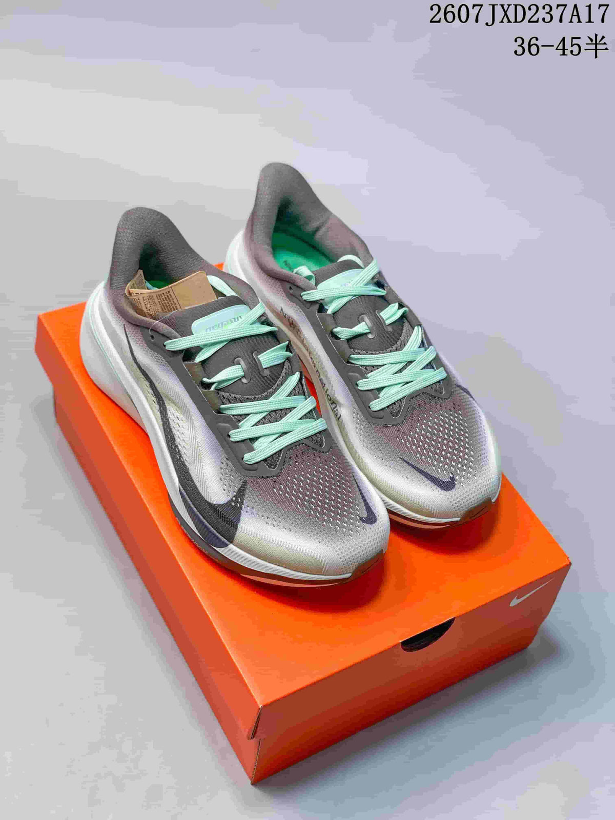 Pair of gray and mint Nike Air Zoom Pegasus 42 sneakers displayed on an orange shoe box.
