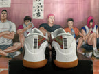 Rear view of white basketball shoes with patterned panels and gum-colored outsoles