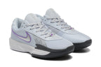 Pair of pale grey Nike tennis shoes with purple Swoosh accents, shown at an angle