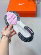 Underside view of the sneaker showing the black segmented rubber outsole and pink outsole sections.