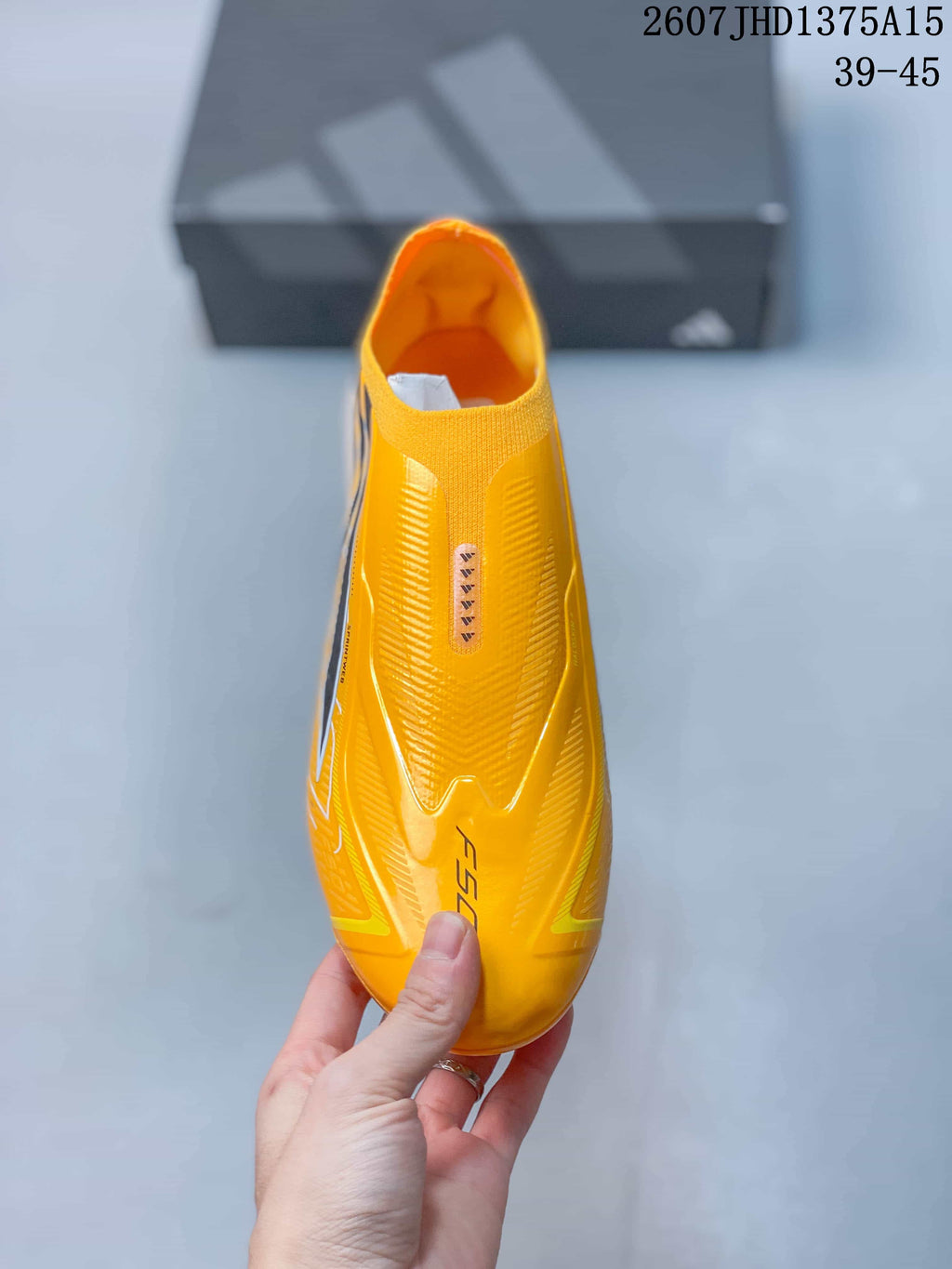 Top view showing the laceless yellow upper, textured surface detailing, and F50 branding.