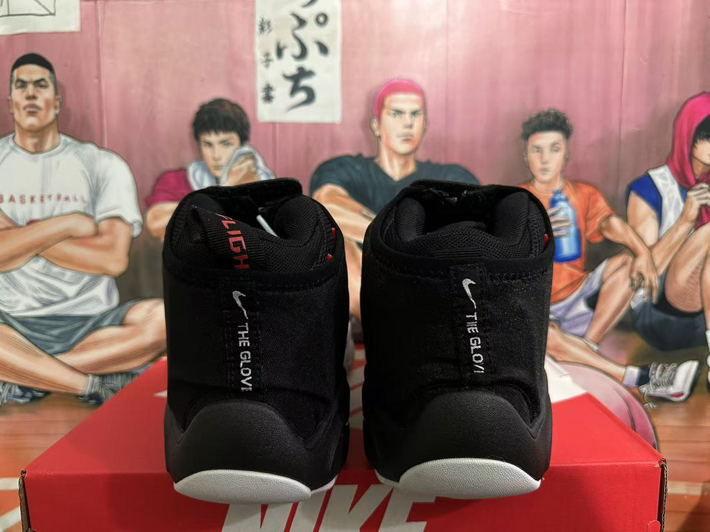 Rear view of black high-top Nike basketball sneakers showing padded collars, red interior accents, white vertical text, and contrasting white outsole sections.