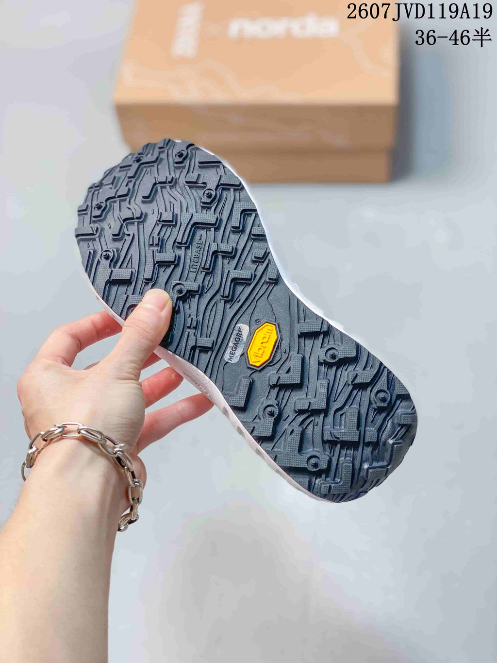 Close-up of the black lugged outsole showing multidirectional tread and visible Vibram branding.