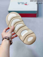 Close-up of the sneaker outsole showing a patterned beige rubber tread and FILA branding.