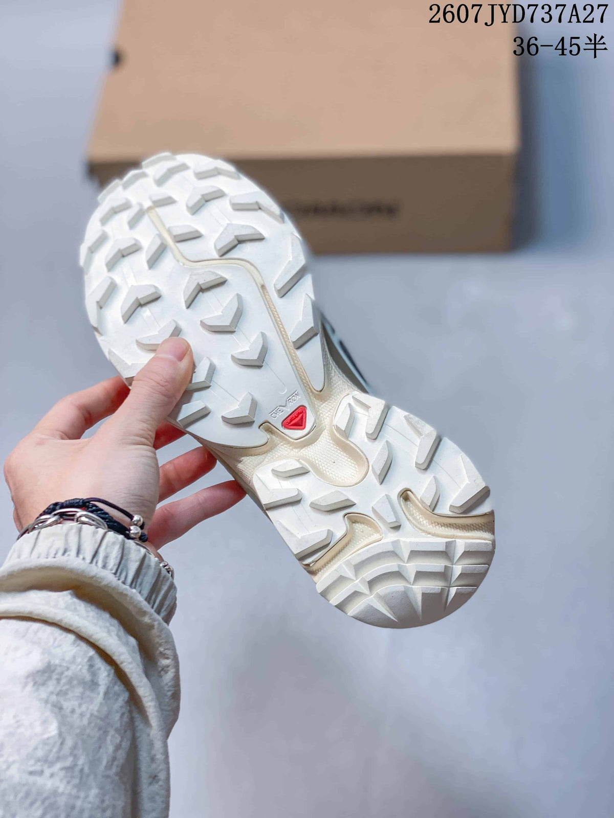 Close view of the white outsole with large traction lugs and a Salomon logo detail.