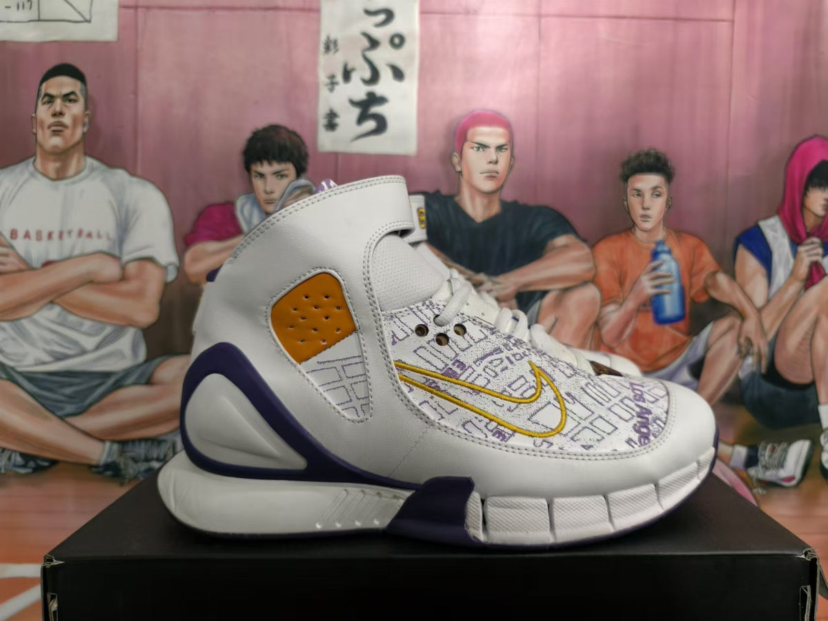 Side view of a high-top basketball sneaker with map-inspired print, gold Swoosh detail, and purple accents.