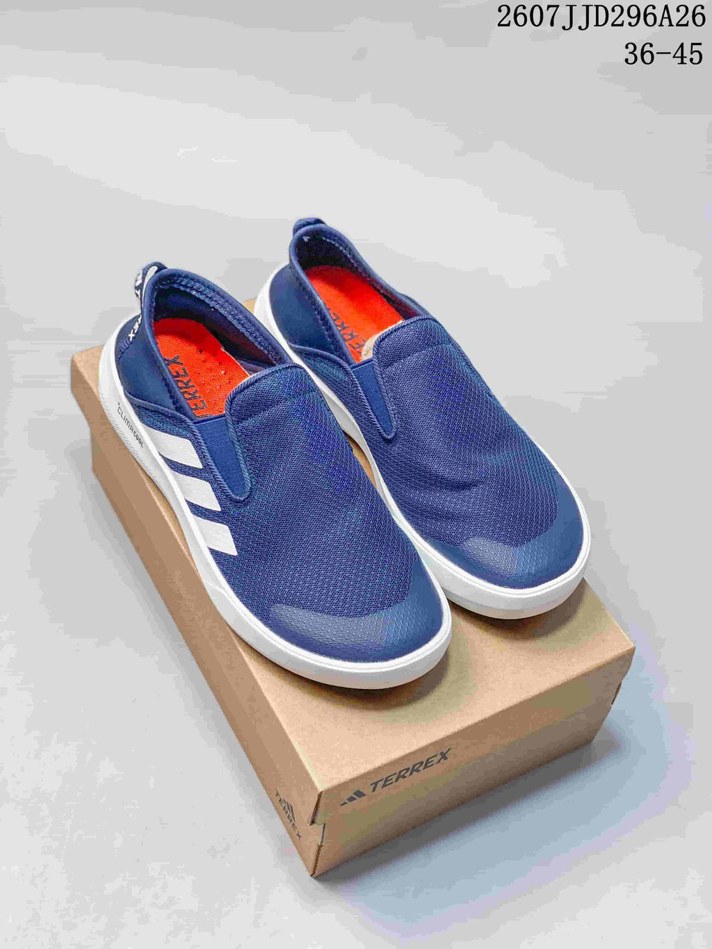 Pair of navy Adidas TERREX slip-on shoes on a TERREX box, with the product code and size range visible above.