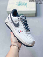 Angled side view of the white and black sneaker showing the dark Swoosh, Air-marked midsole, decorative accents, and outsole.