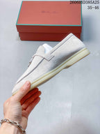 Side profile of the light beige loafer showing its low sole and strap detail