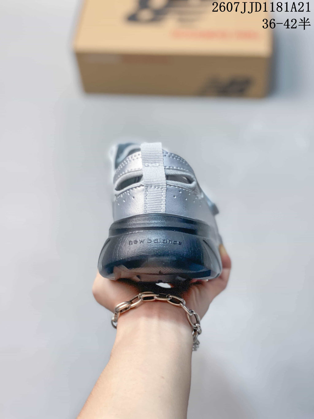 Rear view showing the heel pull tabs, silver upper and dark outsole.