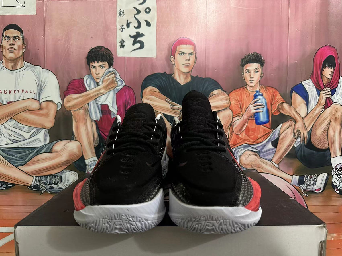 Front view of black basketball shoes with red outsole accents
