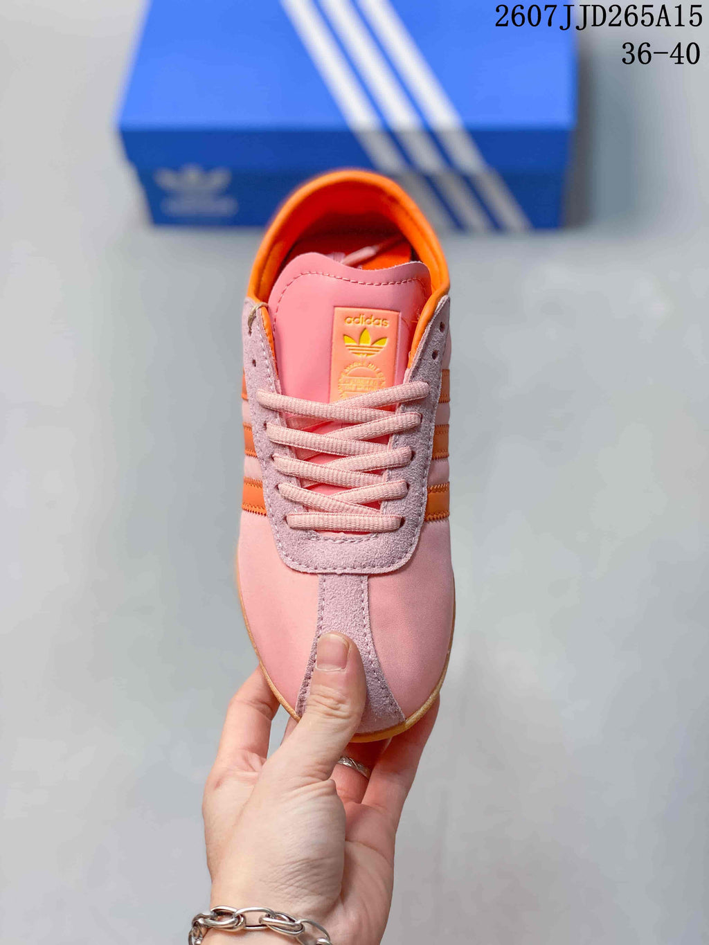 Top view showing the pink tongue, orange lining, pink laces, and adidas branding.