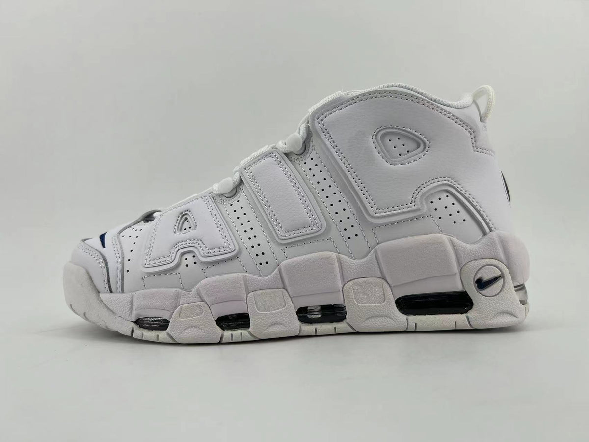 Side view of white Nike Air More Uptempo sneakers with oversized side lettering and a chunky sole