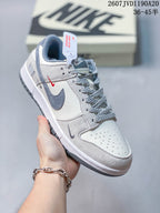 Angled side view highlighting the grey Swoosh, small red Swoosh detail, layered panels, and low-top shape.