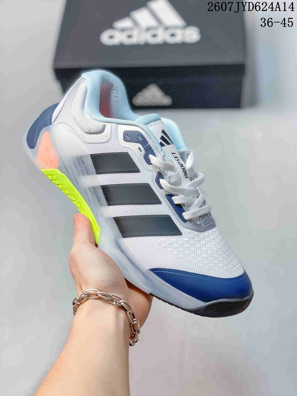 White adidas Dropset 4 training shoe with black and navy details and a bright yellow-green outsole accent.