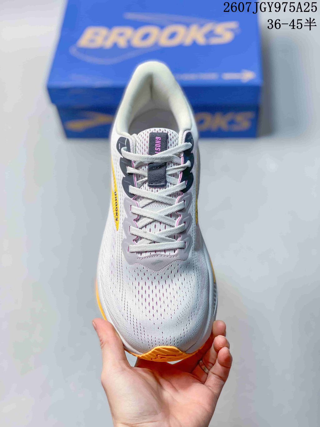 Top view of the white lace-up sneaker showing the perforated-looking toe area and gray lace supports.