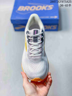 Top view of the white lace-up sneaker showing the perforated-looking toe area and gray lace supports.