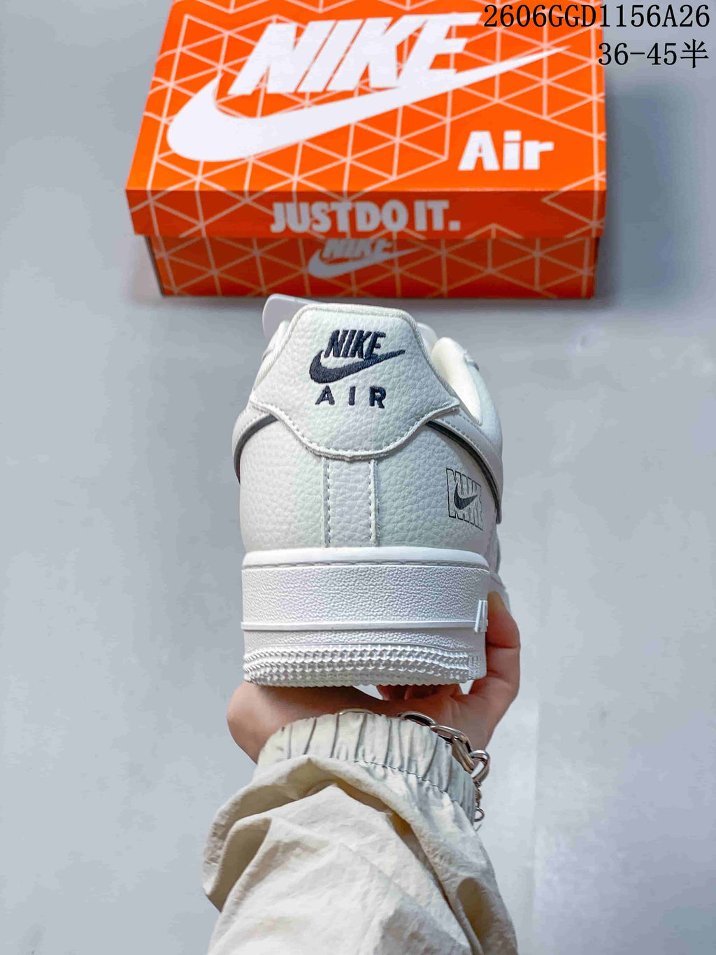 Rear view of a cream-white Air Force 1 sneaker with Nike Air heel branding