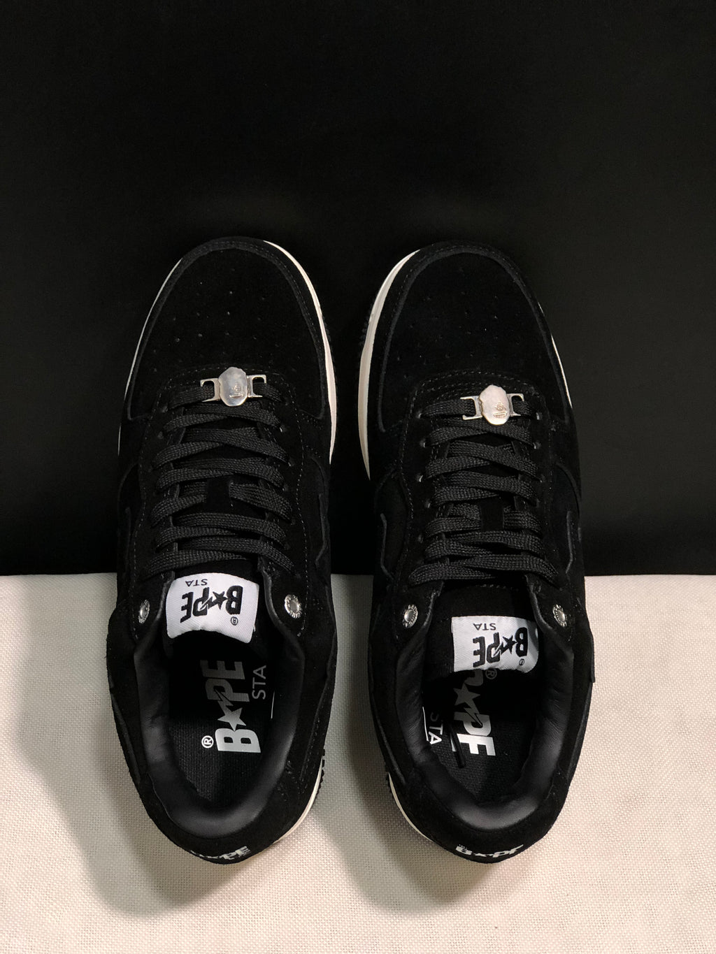 Top-down view showing black laces, padded collars, tongue labels and metal lace accessories.