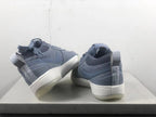 Pair of blue-gray Nike Book 1 shoes shown from the heel, with light-colored midsoles and heel pull tabs.