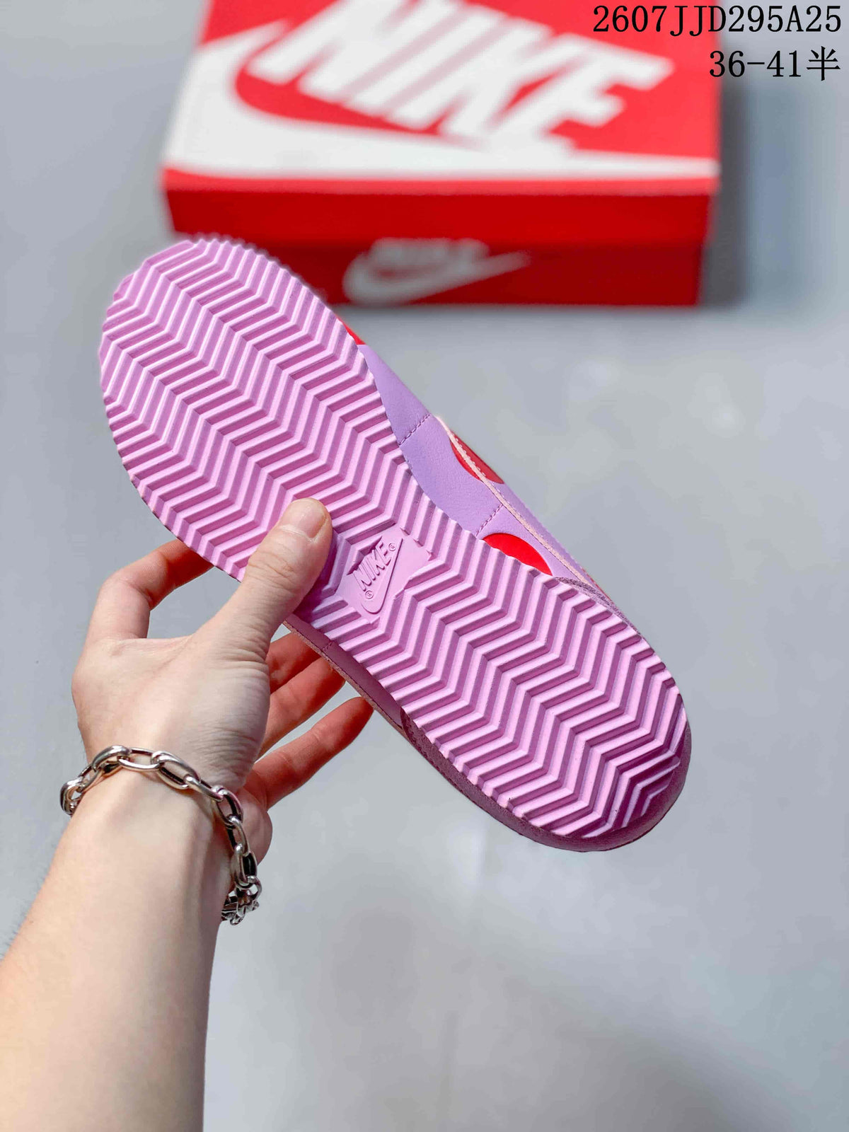 Underside view showing the pink zigzag-patterned rubber outsole and Nike branding.