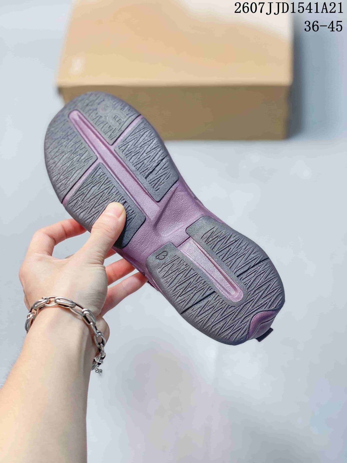 Close view of the patterned rubber outsole on a purple and red sneaker.