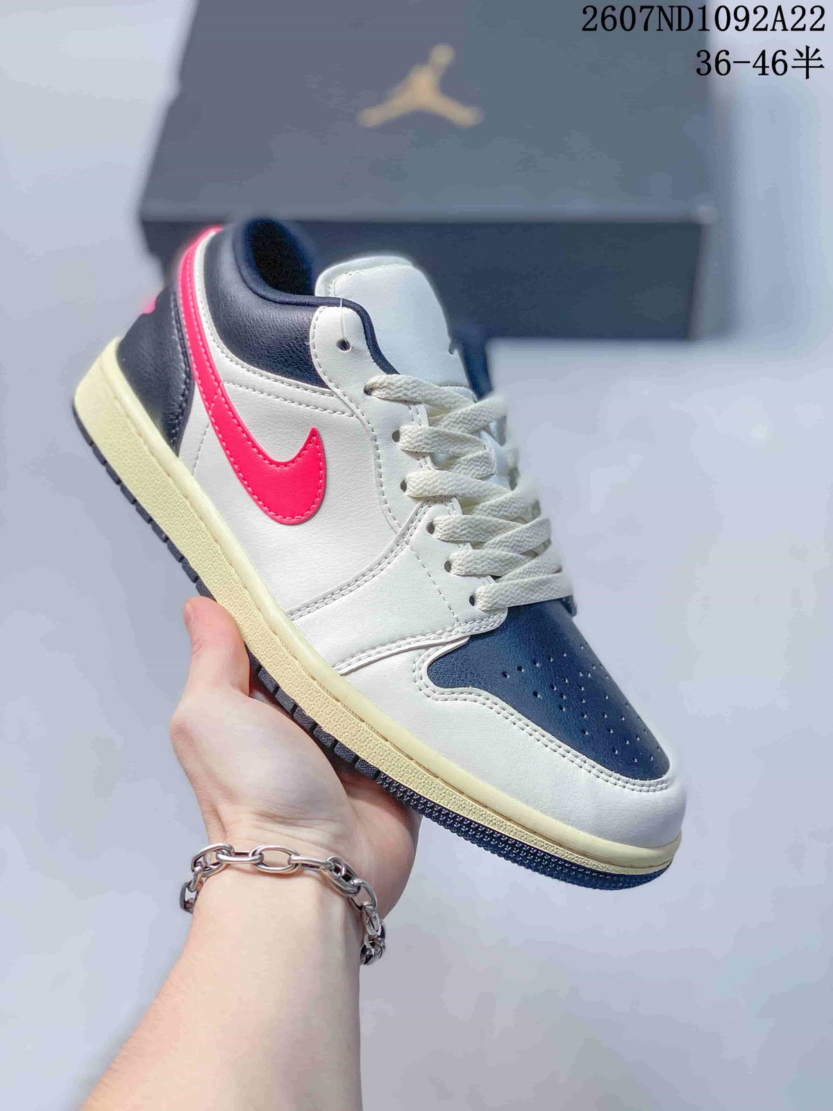 White, navy, and bright pink low-top Jordan sneaker with an off-white midsole.
