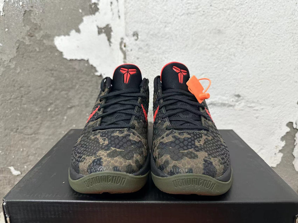 Front view of camouflage Nike Kobe basketball shoes with black laces and red tongue logos