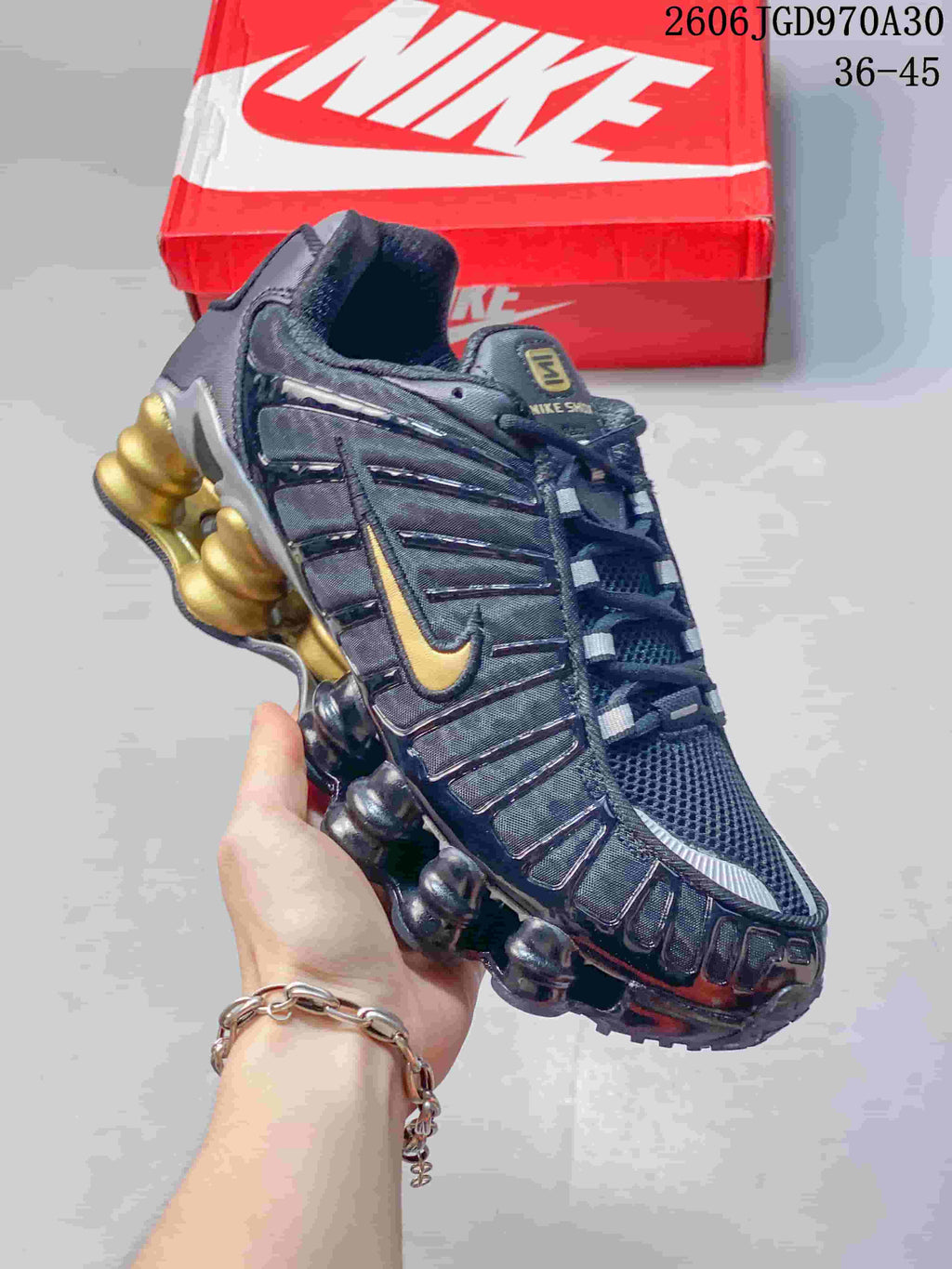 Dark Nike Shox TL sneaker with gold accents