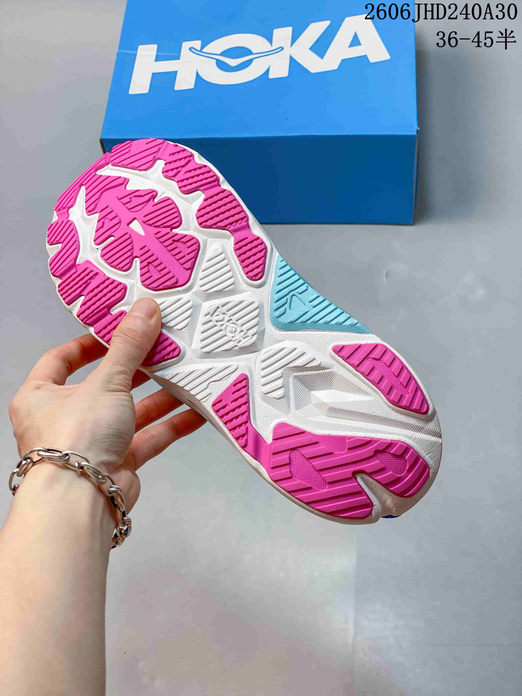 Close-up of the pink, white and aqua outsole on a blue running shoe